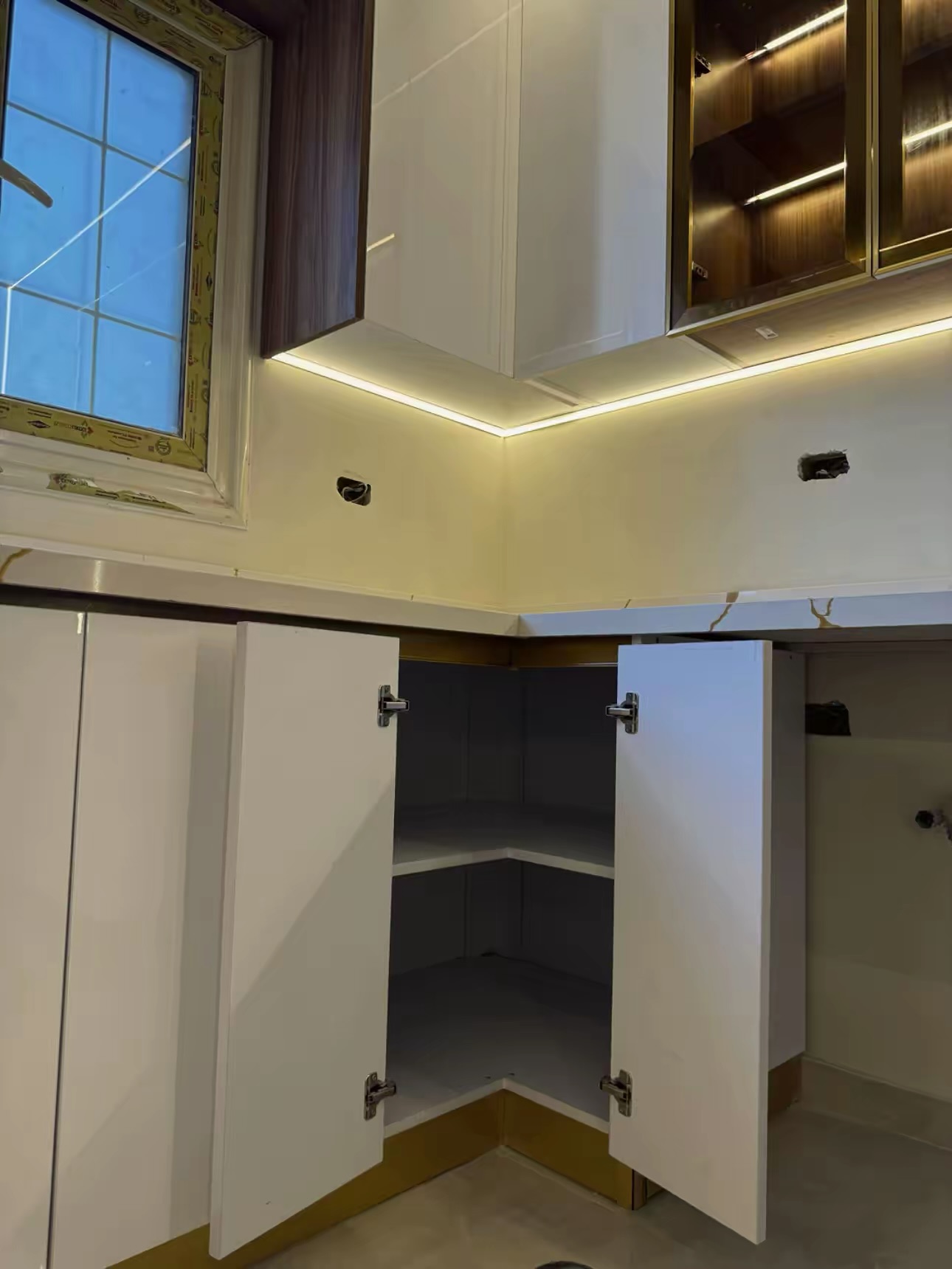 Corner base cabinet with soft-close hinges and lit glass uppers