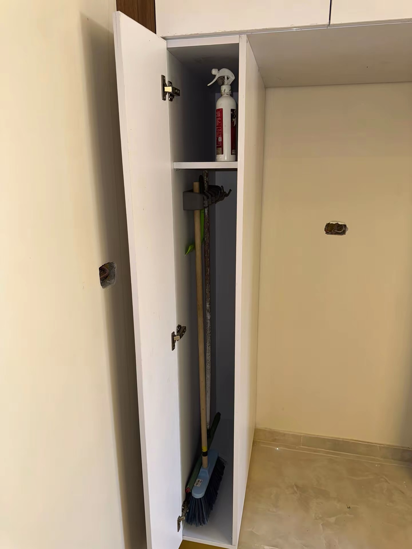Slim utility cabinet with broom holder and shelf