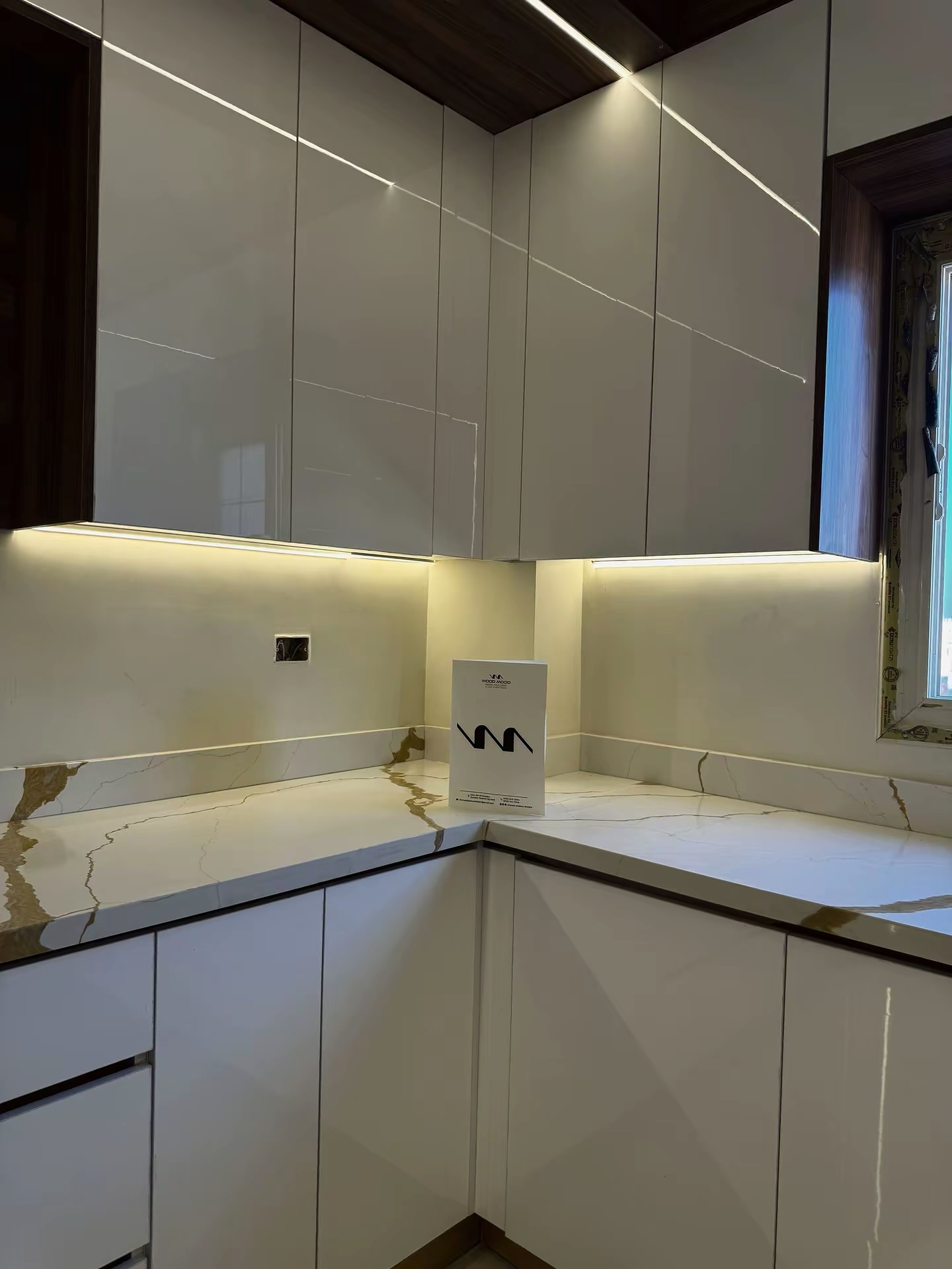 High-gloss handleless upper cabinets with warm under-lighting