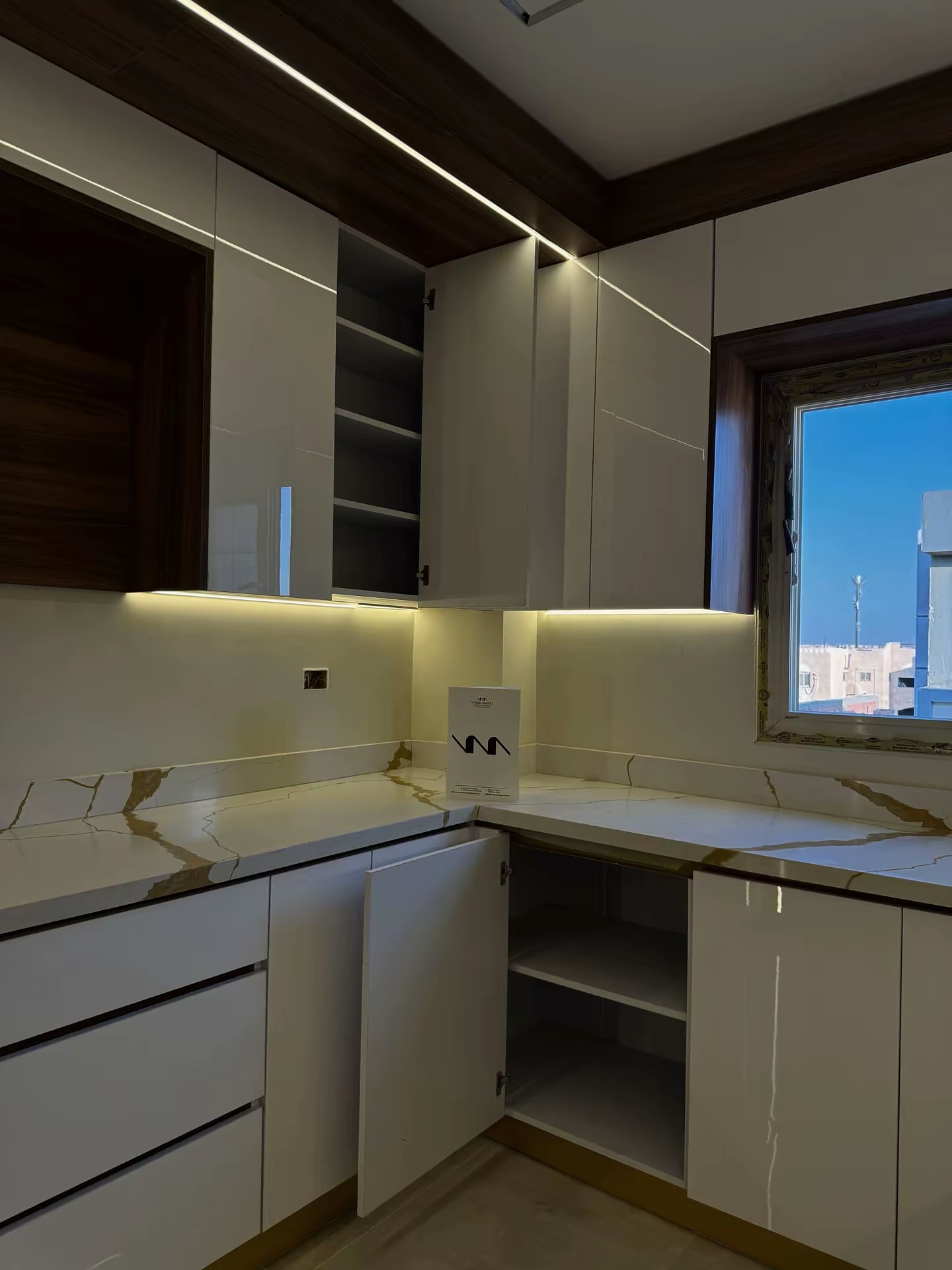 L-shaped kitchen corner with under-cabinet lighting and gold-veined worktop